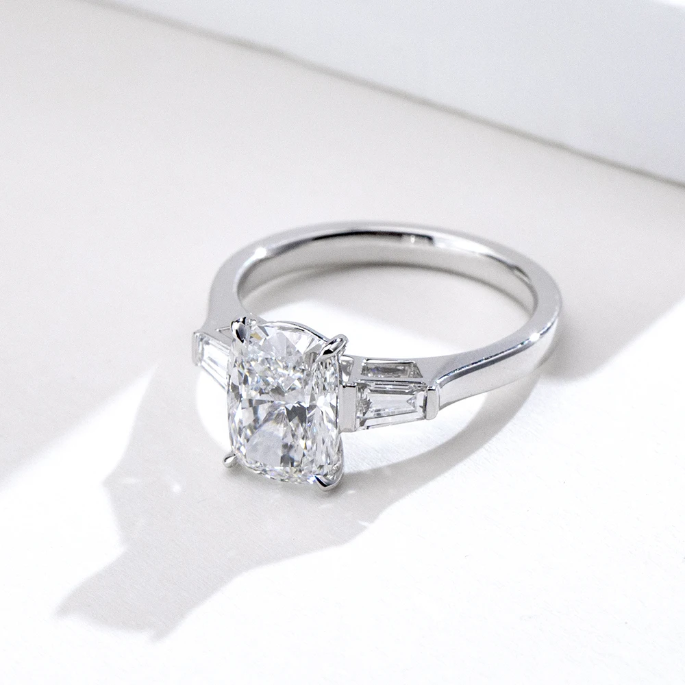cushion cut moissanite ring, three stone engagement ring, baguette side stone ring, white gold plated ring USA, lab grown diamond alternative, luxury engagement ring for women, moissanite jewelry UK, classic bridal ring